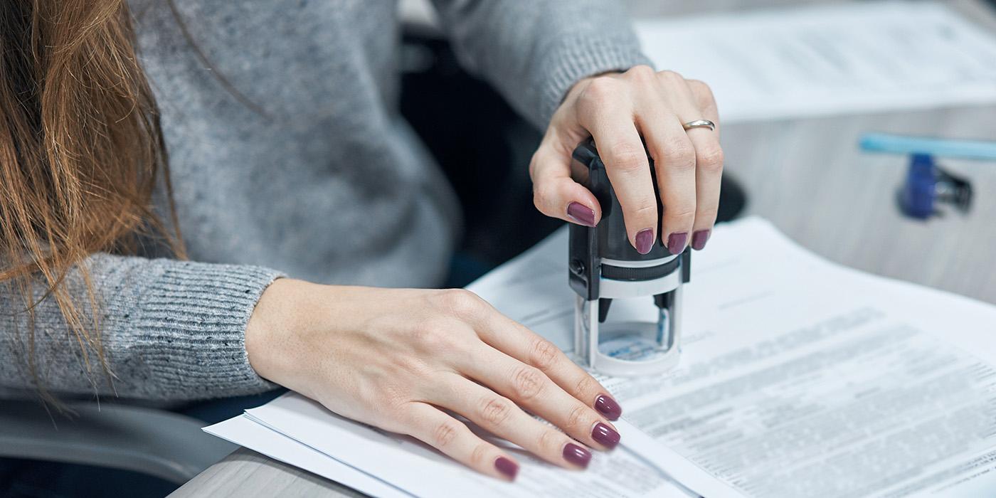 Person using a stamp on a document.